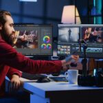 Video editor content creator pressing record button on phone, filming tutorial about professionally trimming footage segments. Videographer teaching online audiences to splice clips